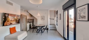 A modern apartment with a dining area, kitchen, and living space.