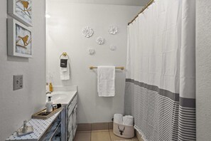 A bathroom with a white sink, a mirror, a towel rack, and a shower curtain. - Cozy PC Condo Top Floor Studio (Park City)