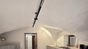 Un espace de vie compact comprenant un coin repas, une kitchenette et une chambre en mezzanine.