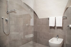 Un baño moderno con ducha, bidé y barra para toallas.