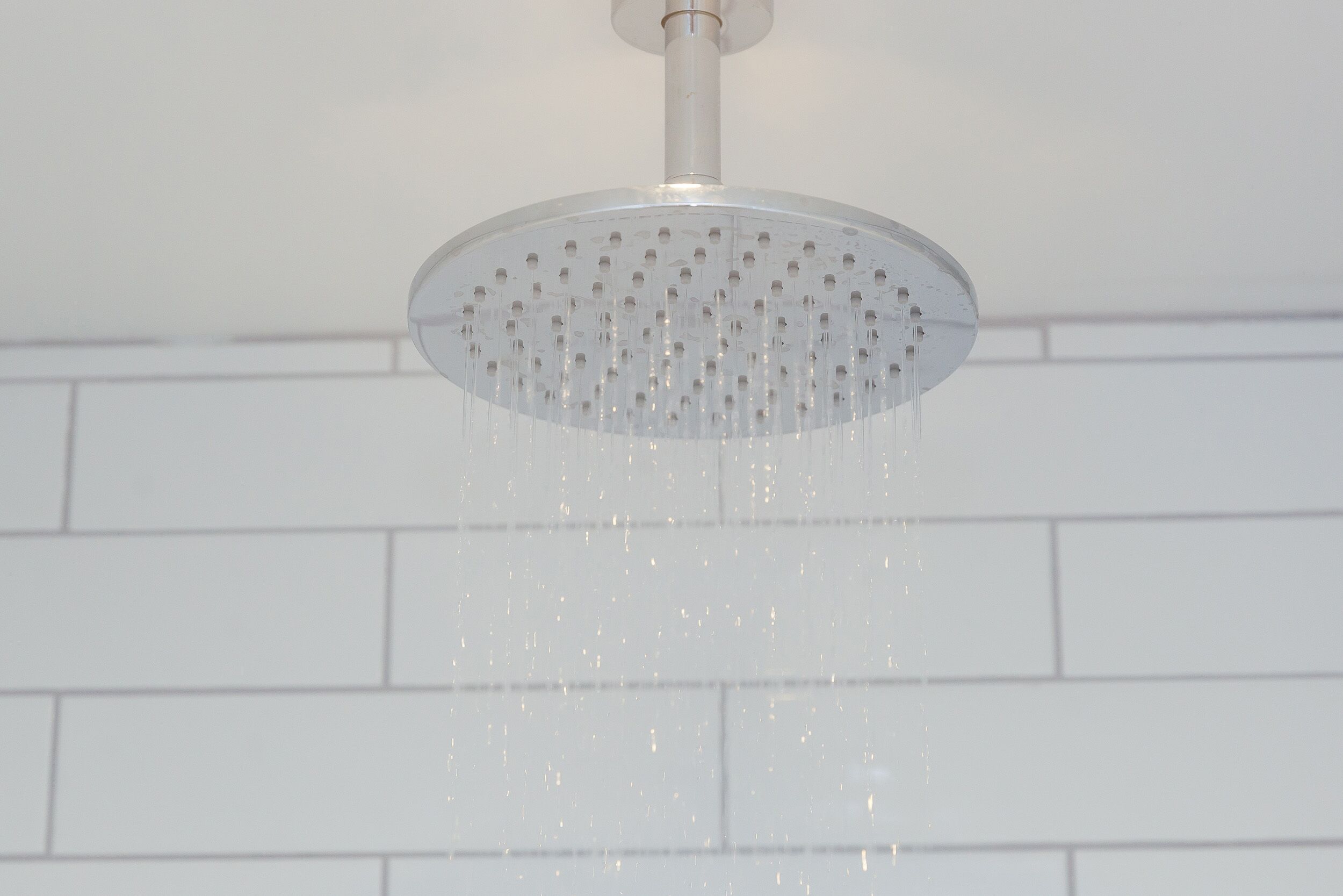 A showerhead with water flowing from it.