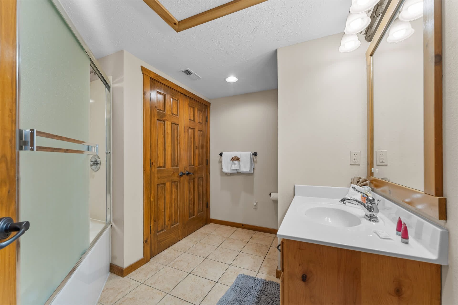 A bathroom with a shower, a sink, and a mirror.