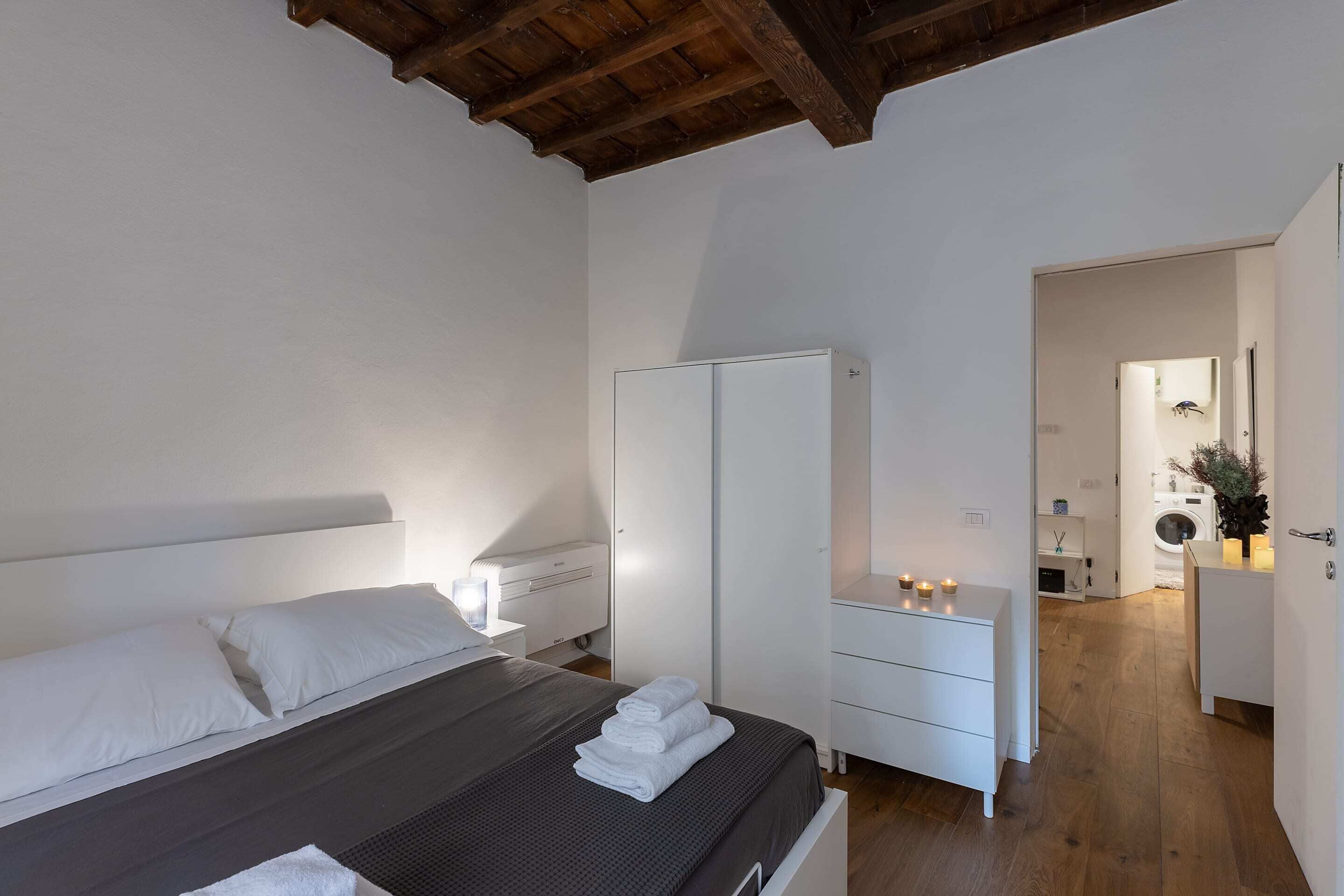 A bedroom with a bed, a wardrobe, a nightstand, and a dresser.