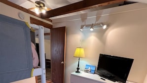 A bedroom with a bunk bed, a TV, a lamp, and a dresser. - Crooked River Cottage Limit 5 2 Bedroom Cottage by RedAwning (Casco)