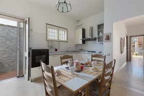 Una cocina moderna con comedor, que cuenta con un amplio ventanal, electrodomésticos de acero inoxidable y una mesa de comedor con sillas.
