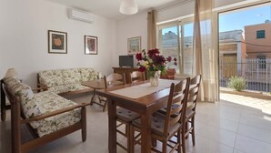 A spacious living room with a wooden dining table, two sofas, and a TV. - 3171 Villino Geremia by Barbarhouse (Porto Cesareo)