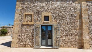 A stone building with a metal gate and a small window. - 2081 Villa Crocilupo by Perle di Puglia (Gagliano del Capo)