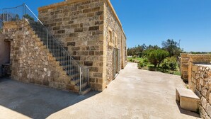 A stone building with a staircase leading to a balcony. - 2081 Villa Crocilupo by Perle di Puglia (Gagliano del Capo)