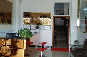 Una cocina moderna con barra, taburetes rojos y una escalera que lleva a un nivel superior.