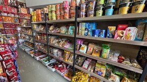 A grocery store aisle with shelves stocked with various packaged goods. - Suyun Express Hotel (Luoping)