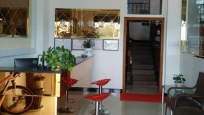 A reception area with a desk, chairs, and a staircase. - Suyun Express Hotel (Luoping)