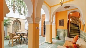 Ein traditionelles Interieur mit Bögen, einem Essbereich und einer Treppe.