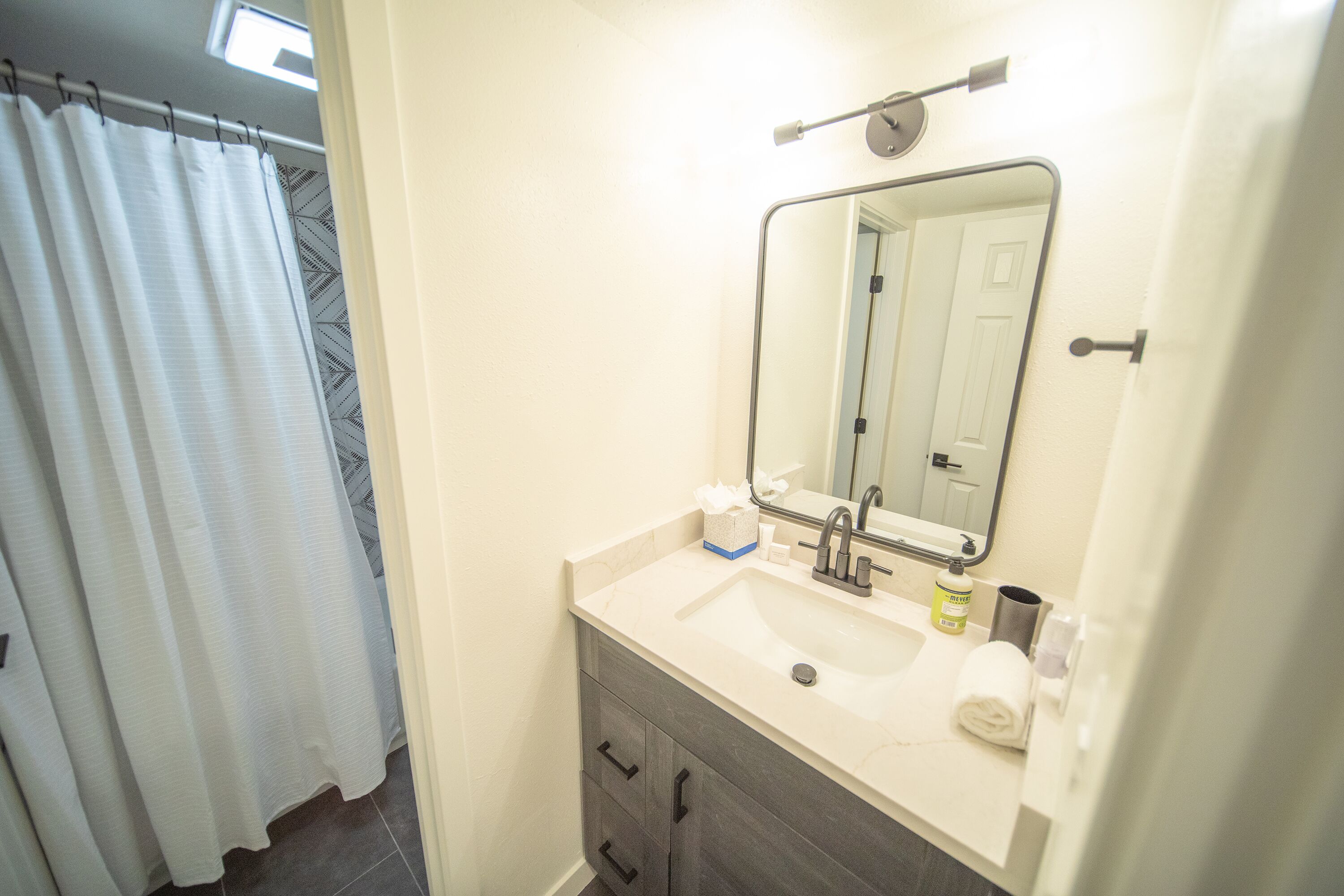 A bathroom with a sink, mirror, and towel.