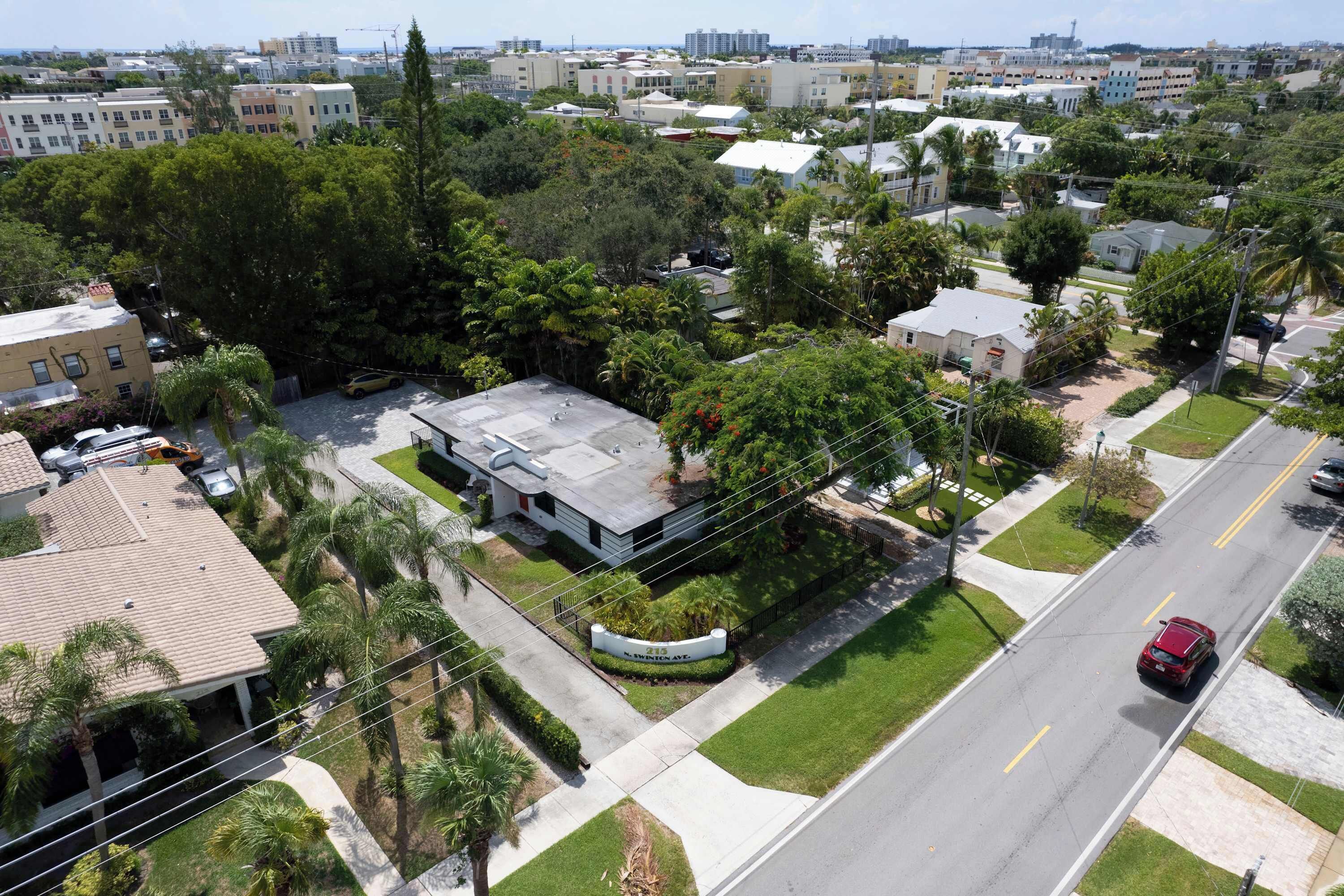 A residential area with houses, a road, and a red car.