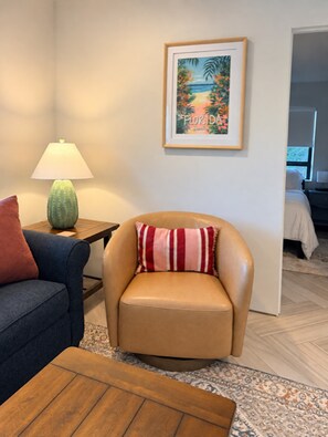 A room with a leather armchair, a wooden coffee table, a lamp, and a framed picture on the wall. - Let Your Delray Beach Getaway Begin Here! (Delray Beach)