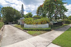 A residential street with a house number sign, a sidewalk, and lush greenery. - Let Your Delray Beach Getaway Begin Here! (Delray Beach)