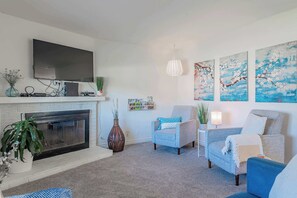 Casa, varias camas, hidromasaje, vista al jardín | Área de sala de estar | Televisión de 40 pulgadas con canales por cable y chimenea