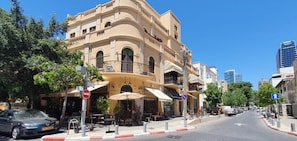 Stylish building with balconies and arched windows, featuring a commercial space on the ground floor.