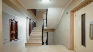 A spacious, well-lit hallway with a staircase leading to an upper floor. - Downtown Stylish Apartment Garage by Vacationy (Porto)