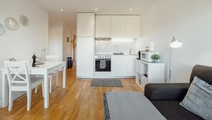 A compact living space with a kitchenette, a dining area, and a seating area. - Downtown Stylish Apartment Garage by Vacationy (Porto)