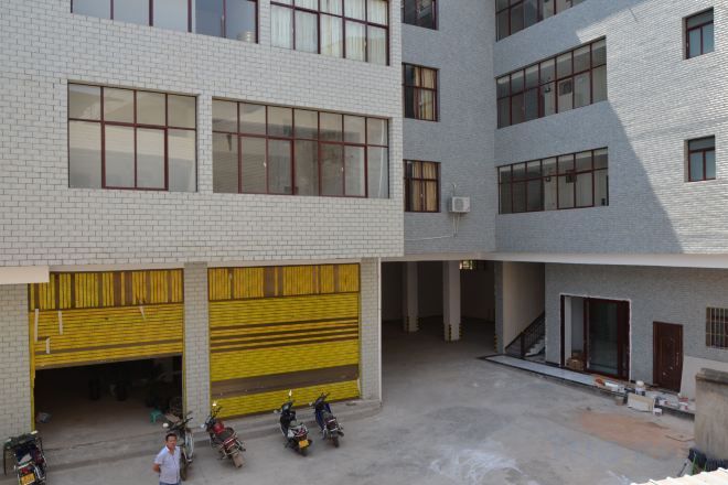 A multi-story building with a courtyard, yellow garage doors, and a staircase leading to an upper level.