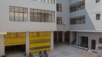 A multi-story building with a courtyard, yellow garage doors, and a staircase leading to an upper level.