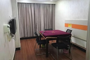 A small meeting room with a table, chairs, a telephone, and a curtain. - Jujin Hotel (Jiangmen)