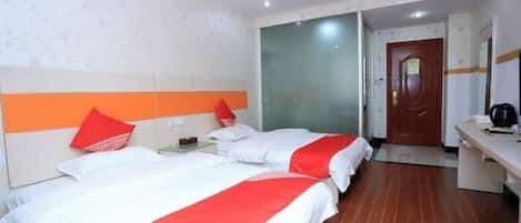A hotel room with two beds, a desk, and a door leading to another room.
