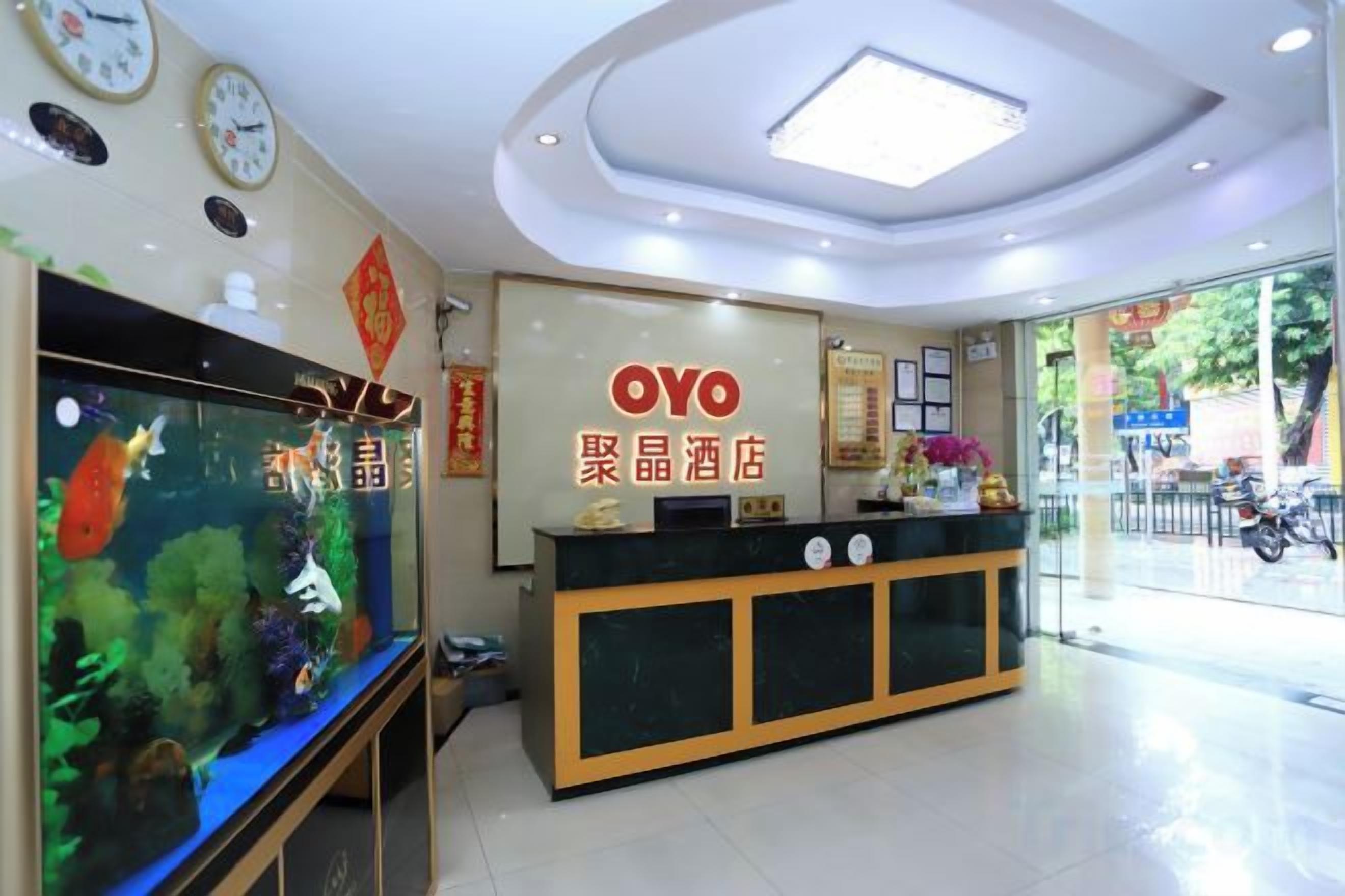 Un hall d'hôtel comprenant un comptoir d'accueil, un aquarium et une grande fenêtre.