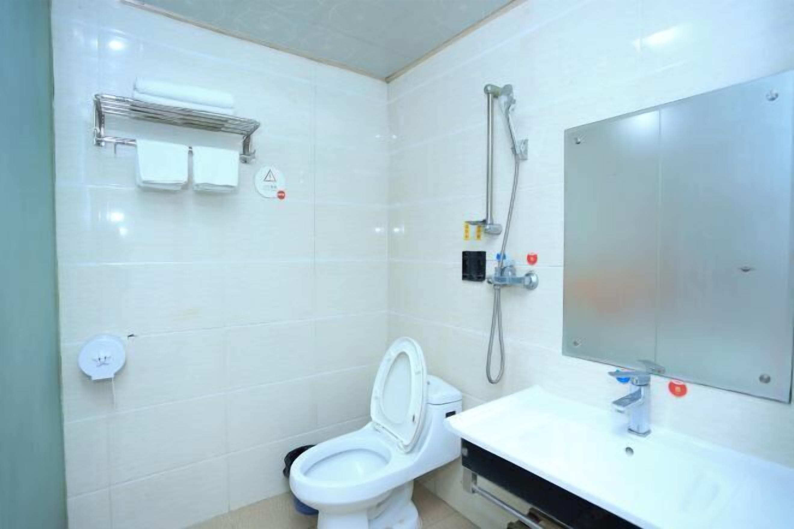 A modern bathroom with a toilet, sink, and shower.