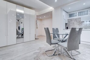 Contemporary kitchen and dining area with a patterned backsplash and rug.