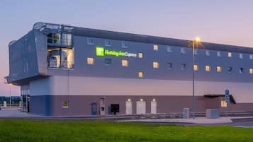 A Holiday Inn Express building with a modern design, featuring a large entrance and multiple windows.