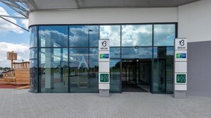 A modern building entrance with glass doors, a Holiday Inn Express logo, and a sign indicating a break area. - Holiday Inn Express Hamburg South A7 As42 (Egestorf)