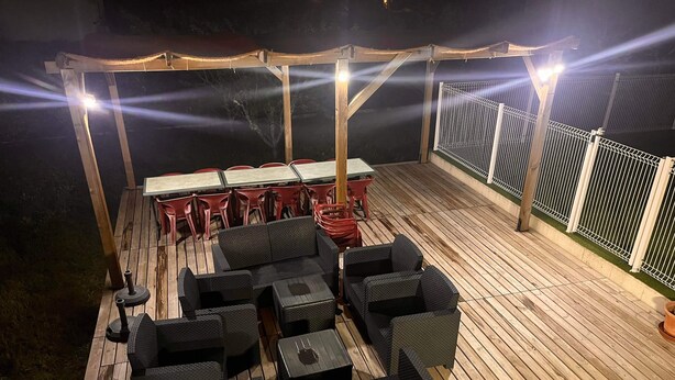 An outdoor deck with wooden flooring, black wicker furniture, and a table with chairs. - VILLA 14 Pers. Private pool, pétanque, terrace. 1km from Vallon center (Vallon-Pont-d'Arc)
