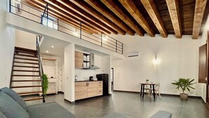 A spacious living area with a staircase, a kitchen, and a dining area. - Palermo Inn Boutique Hotel  (Palermo)