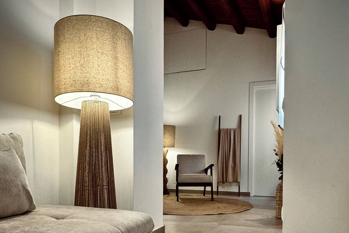 A modern living room with a sofa, a floor lamp, and a chair.