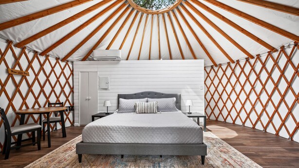 A room with a bed, bedside tables, and a patterned rug. - Ot 3515j Texas Yurt Haus: Javelina 1 Bedroom Cabin by RedAwning (New Braunfels)
