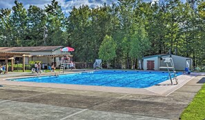 A swimming pool with a diving board, a covered seating area, and a small building with a door. - Lakes and Beaches with Resort Amenities at The Hideout (Hamlin)