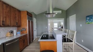 A kitchen with wooden cabinets, a built-in oven, and a central island with seating.