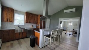 A kitchen with wooden cabinets, a stainless steel sink, and a white countertop.