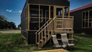 A small wooden cabin with a balcony and a staircase leading to a deck area. - Willow Springs Marina (Mead)