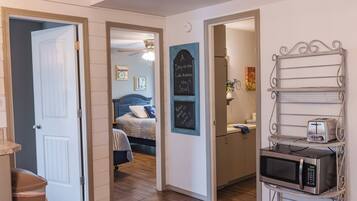 A hallway with a bed, a microwave, and a chalkboard with motivational messages.
