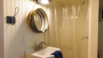 A bathroom with a sink, mirror, and shower curtain.