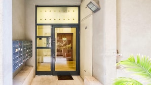 A building entrance with a glass door, a mailbox, and a small step leading up to it. - Dizengoff Muguet in Tel Aviv-yafo (Tel Aviv)