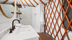 A modern bathroom with a white sink, wooden beams, and a lattice partition. - Ot 3515e Texas Yurt Haus: 5 Yurts! 5 Bedroom Cabin by RedAwning (New Braunfels)