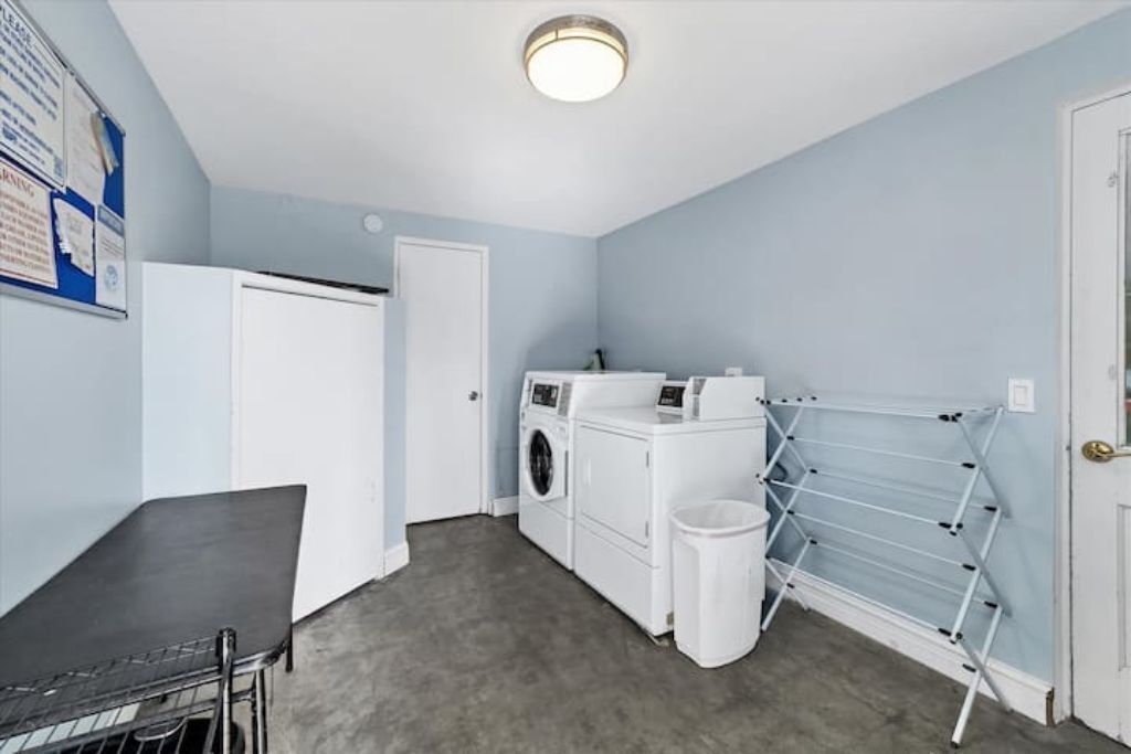 Une buanderie équipée d’un lave-linge, d’un sèche-linge et d’un étendoir.
