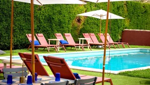 Ett poolområde med solstolar och parasoller.