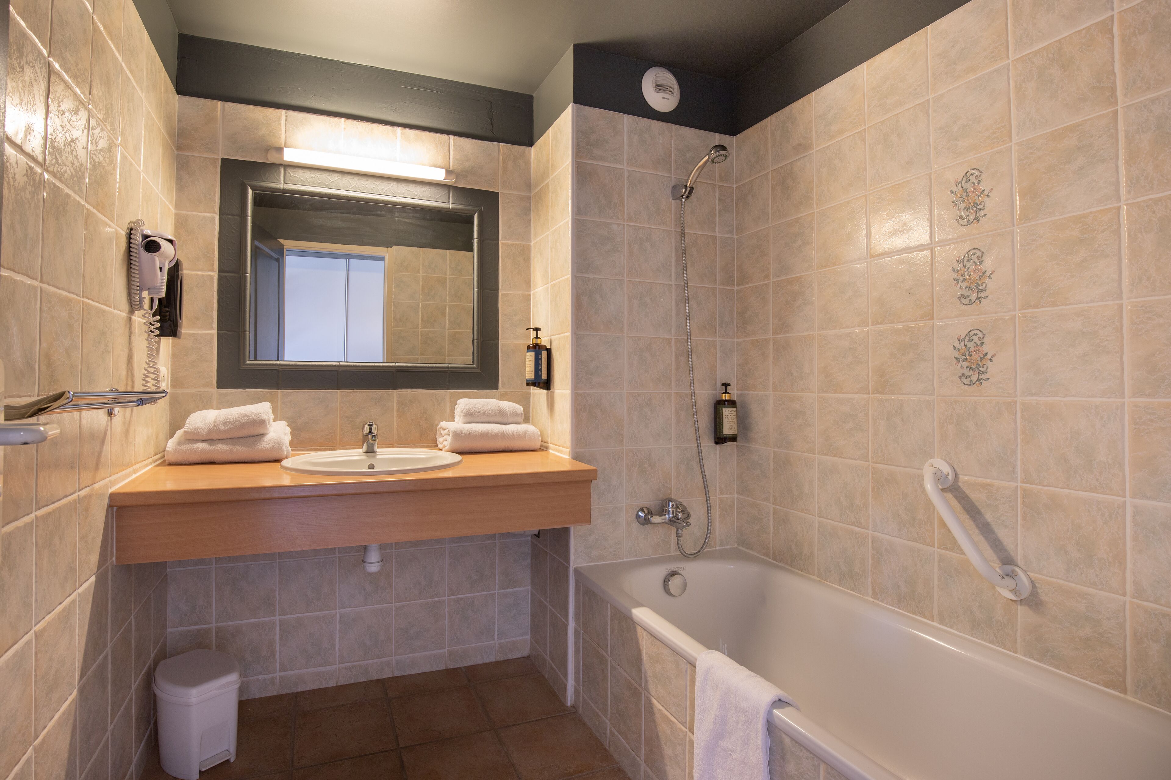 A bathroom with a sink, mirror, and shower.