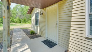 A house with a front porch, a white door, and a welcome mat. - Wooded Danbury Cabin w/ Grill + Fire Pit! (Danbury)