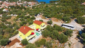 An aerial view of a coastal village with a yellow building featuring outdoor seating and a swimming pool. - Luxury Villa Gaby With Heated Pool (Sali)